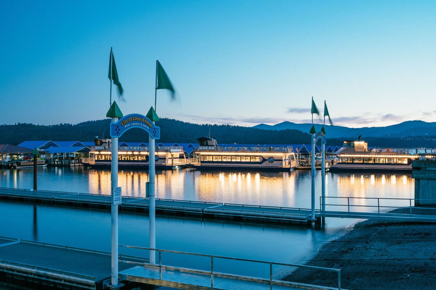City of Coeur d'Alene boat launch with lit cruise boats at dusk