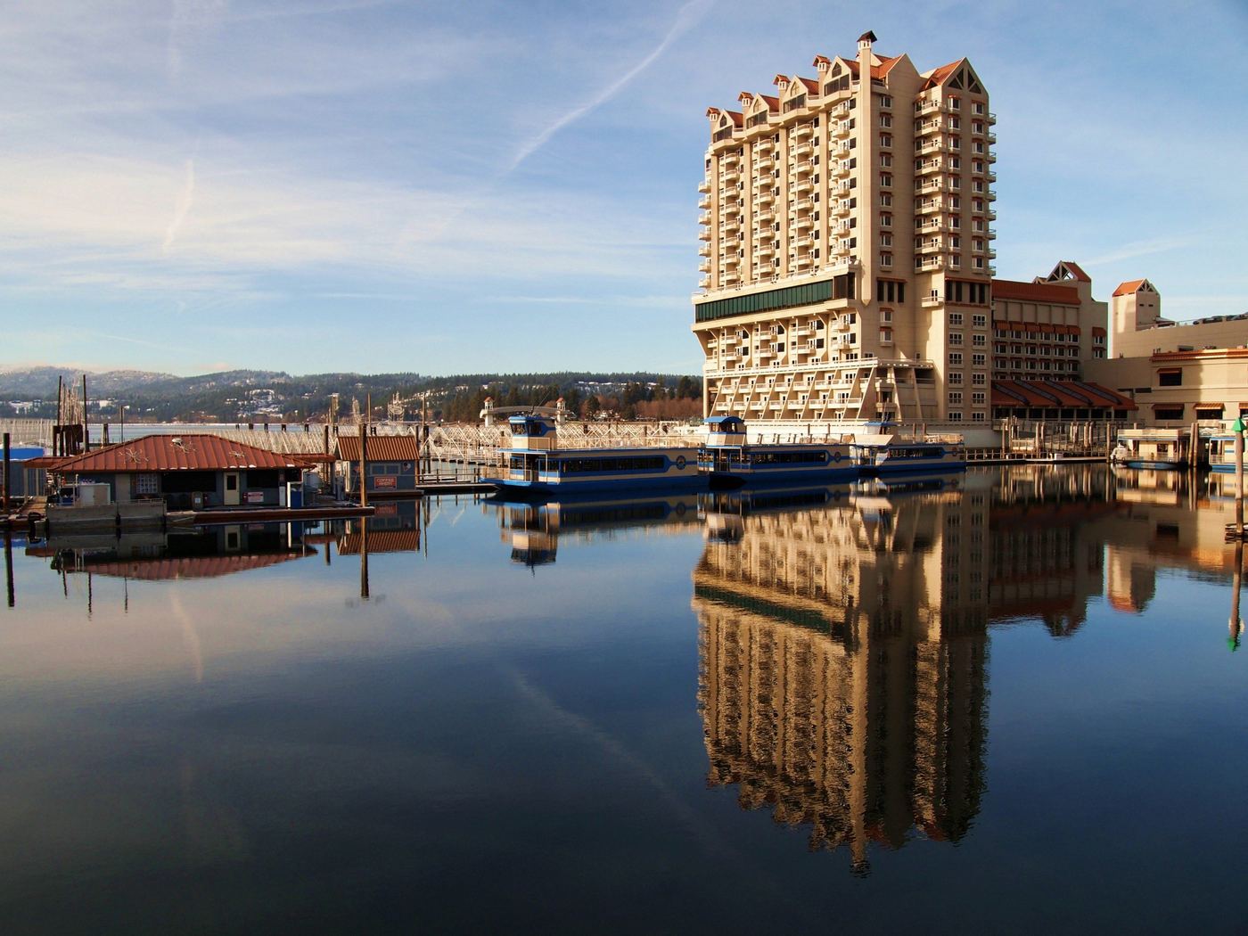 The Coeur d'Alene Resort reflected in calm water on a clear winter day